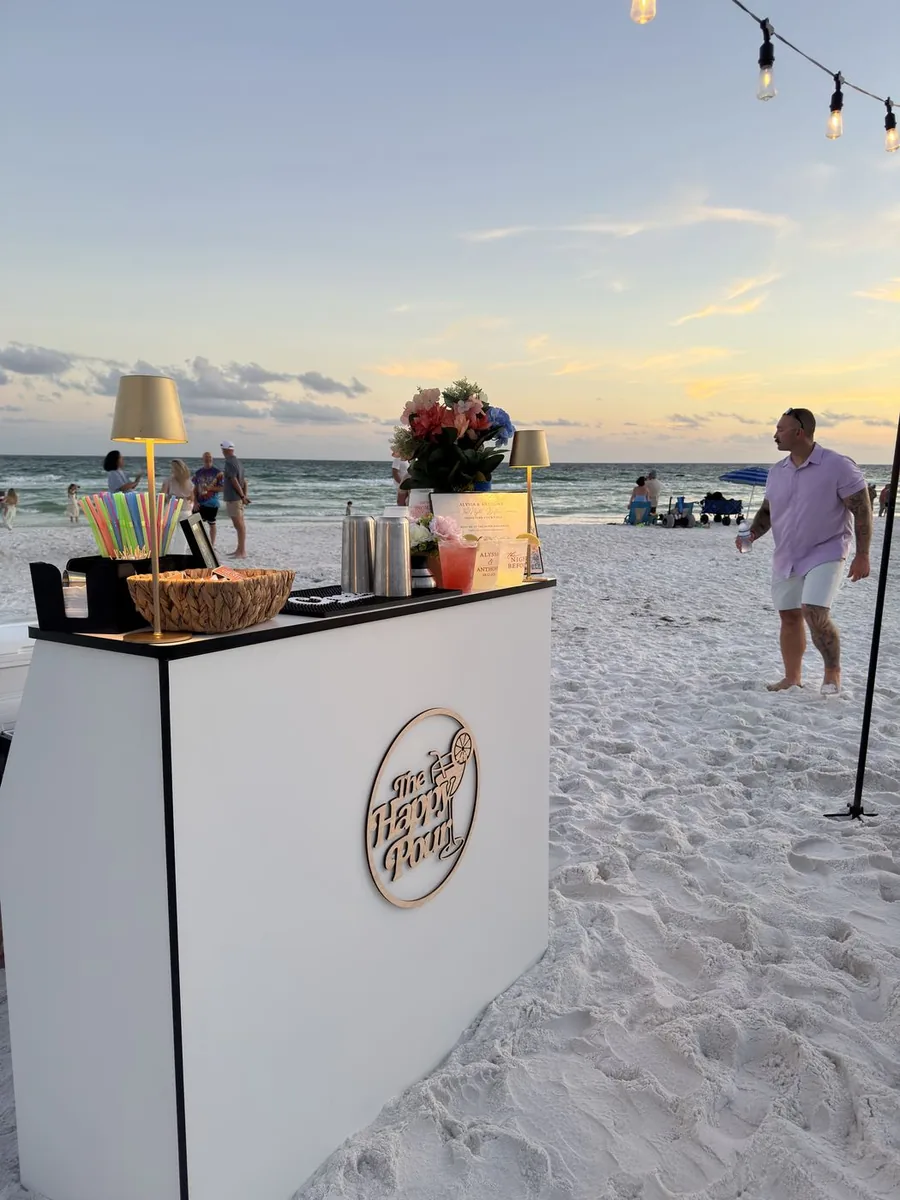The Happy Pour bar set up on the beach at sunset