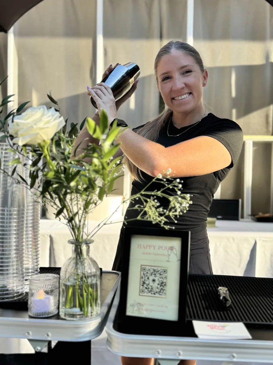 Jacque shaking a cocktail behind the bar at a Happy Pour event