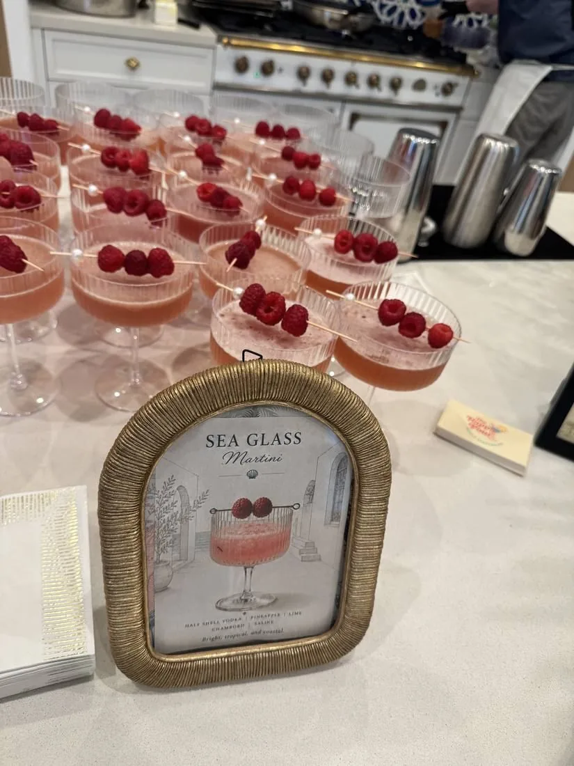 Sea Glass martinis lined up beside a framed cocktail menu