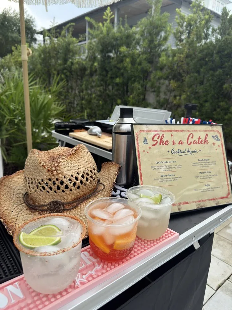 A styled bachelorette bar with a She's a Catch cocktail menu, cowboy hat and fresh drinks